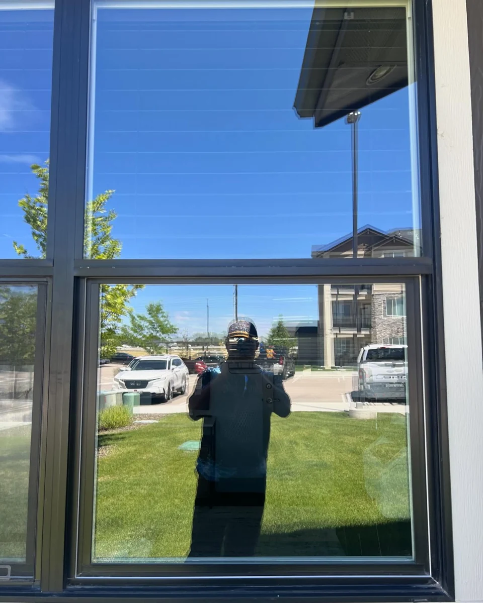 Josias cleaning windows at an apartment property